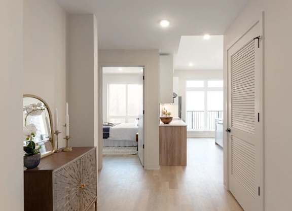 A bedroom with a bed, a dresser, and a mirror.