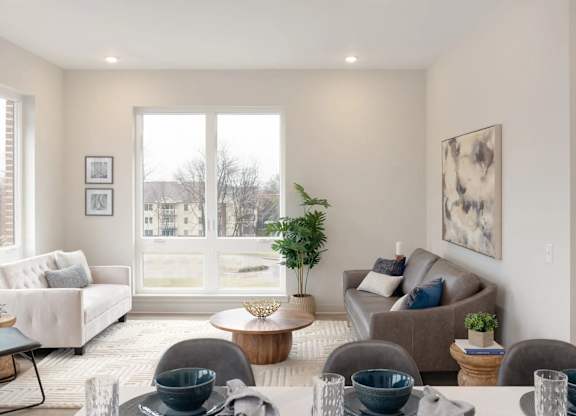 A living room with a couch, chairs, and a table with bowls on it.