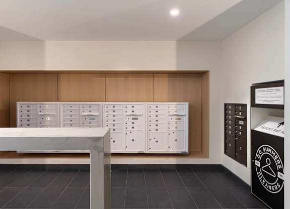 A white table is in front of a wall with a row of white cabinets.