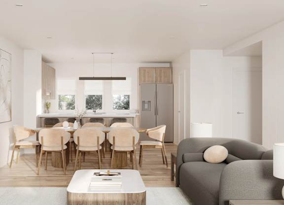 A modern living room with a dining area in the background.