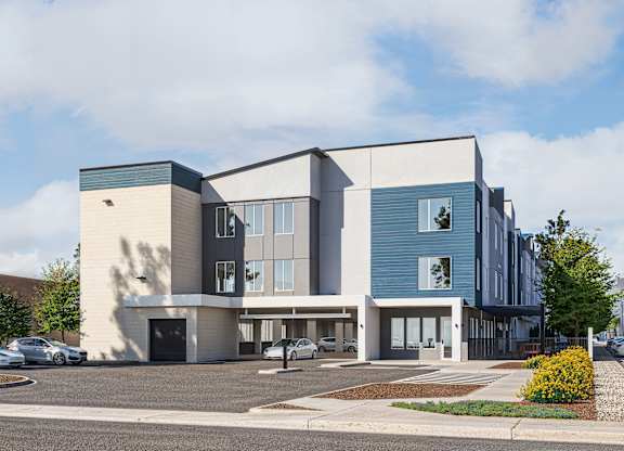 A modern building with a parking lot in front.