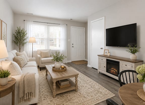 A living room with a white couch, a wooden coffee table, and a fireplace.