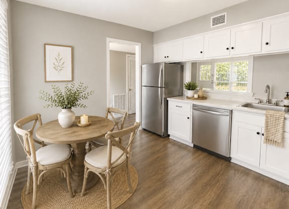 A kitchen with a table and chairs in the middle of the room.
