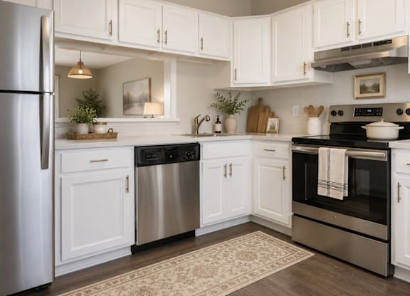 A kitchen with white cabinets and stainless steel appliances.