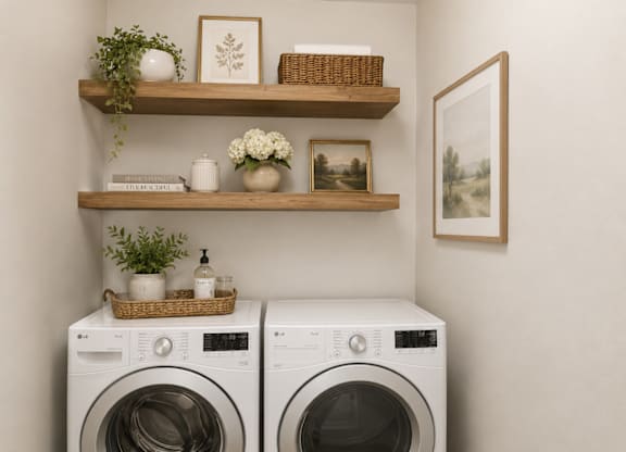 Two front load washing machines are placed in a laundry room.