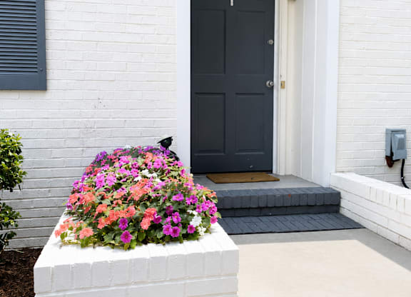 A white house with a black door and a flower box.