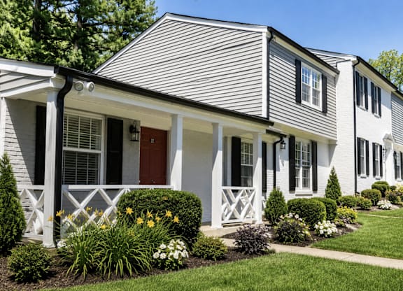 A house with a grey siding and white trim.