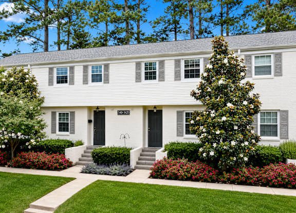 A white house with a black front door and windows.