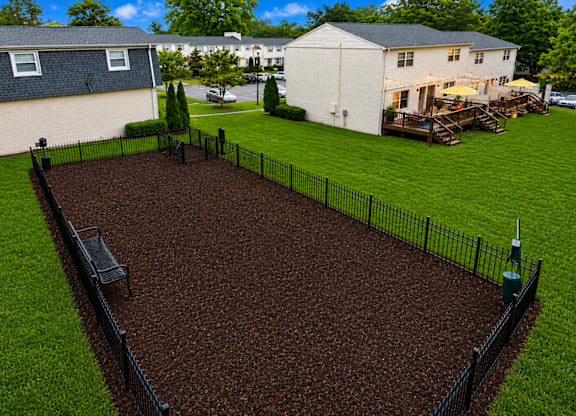 A black fence surrounds a brown dirt area.