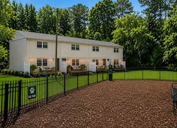 A white house with a black fence and a sign that says "Dix Hill".