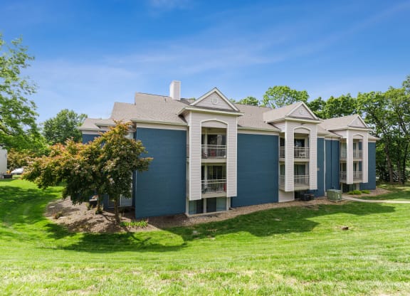 a blue house with white trim and a green lawn at Eastwood Crossings, Missouri, 64129