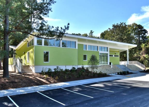 the front of a green house with trees and a parking lot at Parkside at Five Points Apartments, Raleigh , NC 27608
