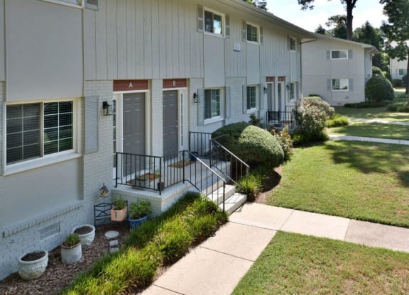 a white house with a sidewalk in front of it at Parkside at Five Points Apartments, North Carolina, 27608