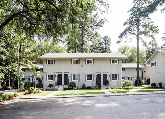 a white house with a street and trees in front of it at Parkside at Five Points Apartments, North Carolina