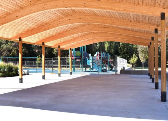 a covered pavilion with a playground in the background at Parkside at Five Points Apartments, Raleigh , NC