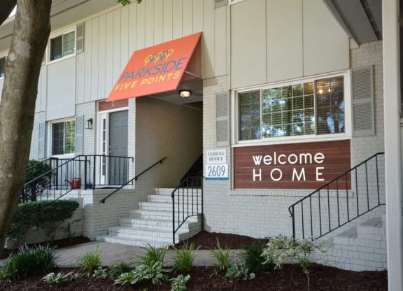 the front entrance of an apartment building with a welcome home sign at Parkside at Five Points Apartments, North Carolina