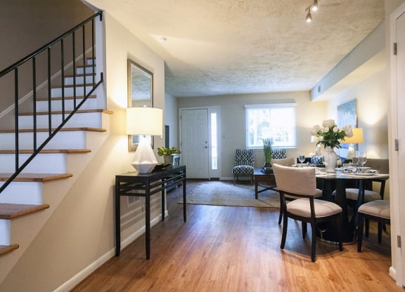 a living room and dining room with a staircase in a house at Parkside at Five Points Apartments, North Carolina