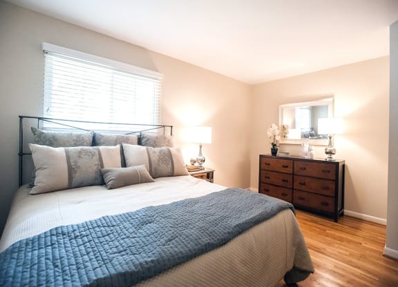 a bedroom with a bed and a dresser and a window at Parkside at Five Points Apartments, Raleigh , NC 27608