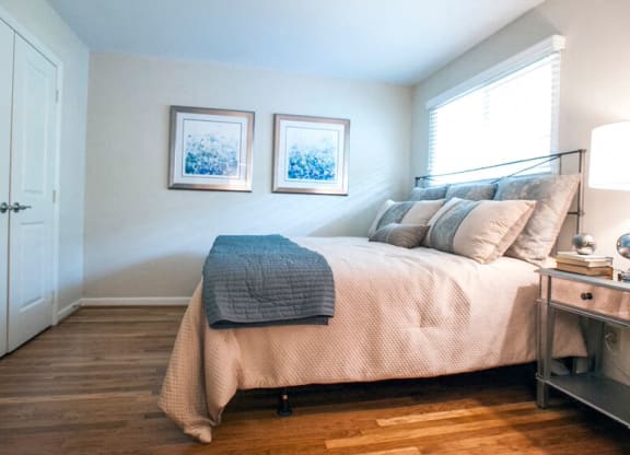 a bedroom with a bed and two pictures on the wall at Parkside at Five Points Apartments, Raleigh , North Carolina
