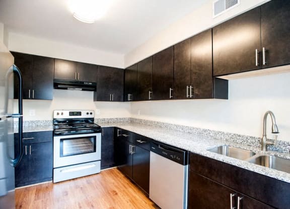 a kitchen with a stove and a sink at Parkside at Five Points Apartments, North Carolina