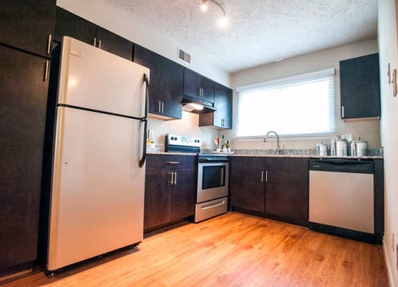 a kitchen with stainless steel appliances and a wood floor at Parkside at Five Points Apartments, Raleigh , 27608