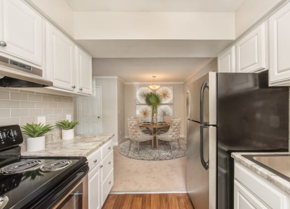 a kitchen with white cabinets and a dining room at Lodge of Overland Park Apartments, Overland Park , 66212