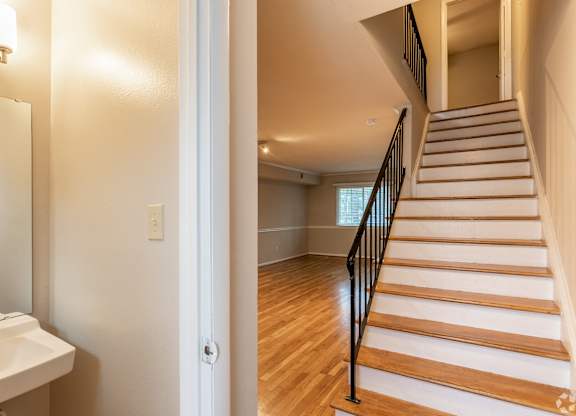 A staircase with wooden steps and a black railing.