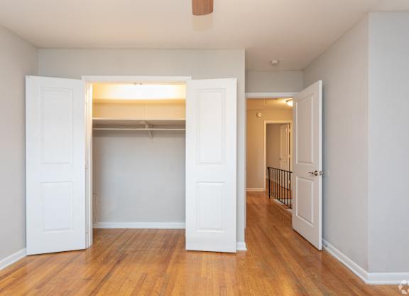 A room with a white door and a wooden floor.