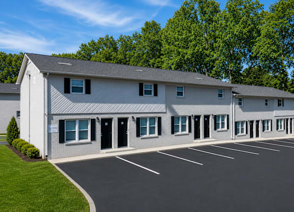 A large white building with a parking lot in front.