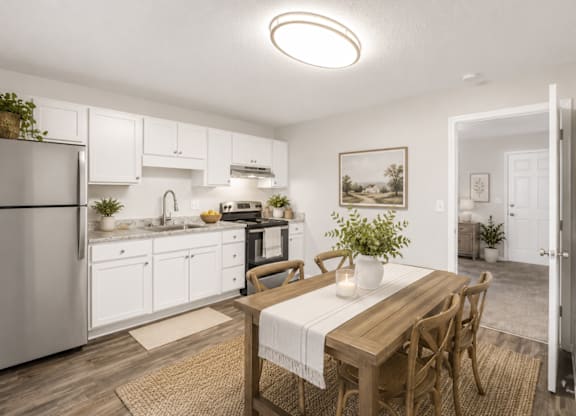 A kitchen with a table and chairs in the middle of the room.