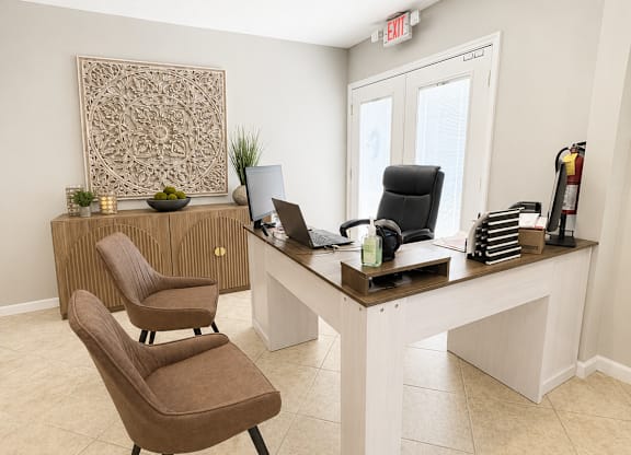 A room with a brown chair and a white desk.