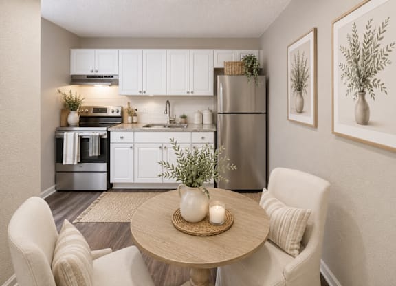 A modern kitchen with a dining table set for two.
