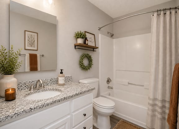 A bathroom with a white toilet, sink, and bathtub.