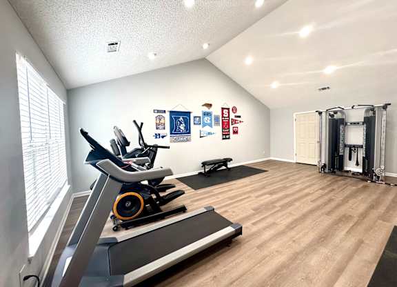 A gym with treadmills, weights, and exercise equipment.