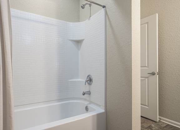 White Bathtub with a Shower at Spring Creek Apartments, Crestview, FL