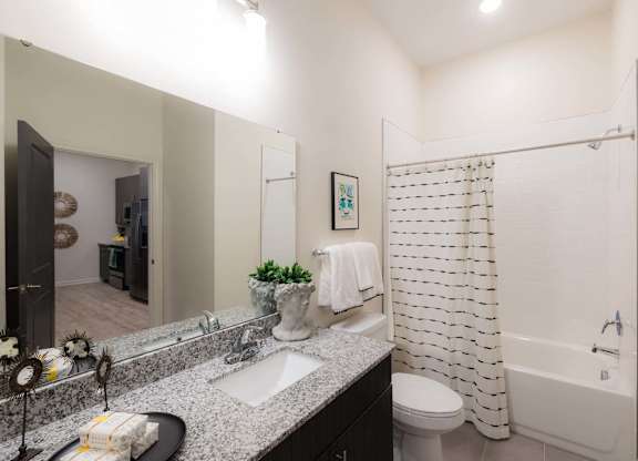 A bathroom with a white shower curtain at Hudson at Renaissance Apartments, Wilmington, NC 28405