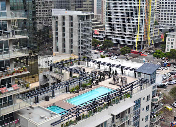 A view of a city from a high angle with a pool in the foreground.