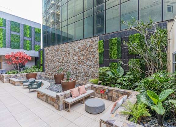 A patio with a stone wall and a green plant wall.