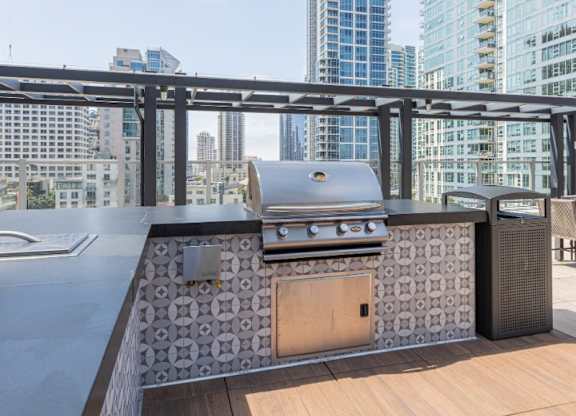 A modern outdoor kitchen with a grill and a table.