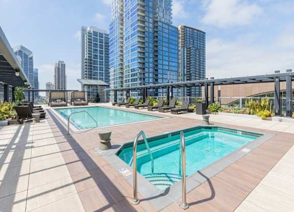 A swimming pool on a rooftop with a cityscape in the background.