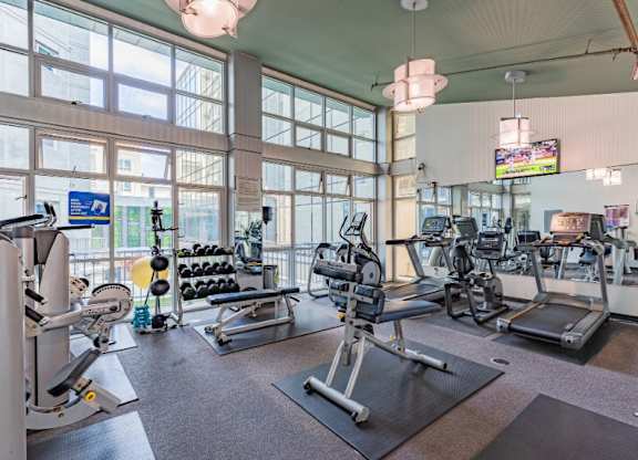A gym with a variety of equipment including treadmills, weights, and exercise machines.
