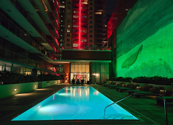 A large indoor swimming pool with a long rectangular shape and a metal railing on the side.