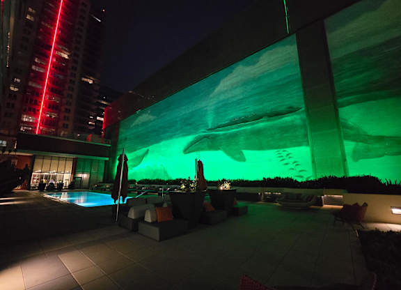A building with a green projection on it at night.