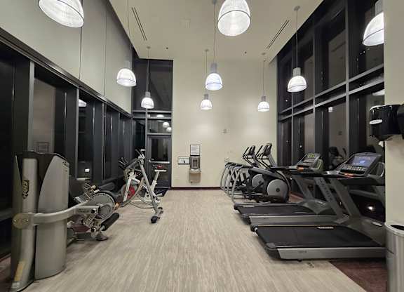 A gym with treadmills, exercise bikes, and elliptical machines.