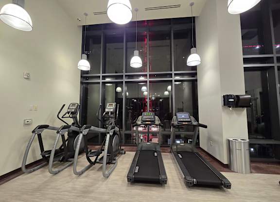 A gym with treadmills, elliptical machines, and exercise bikes.