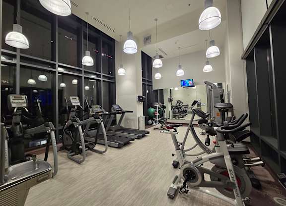 A gym with treadmills, elliptical machines, and other exercise equipment.