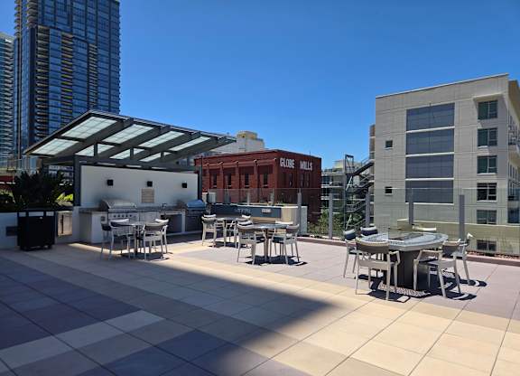 A patio with tables and chairs is in front of a building with a sign that says Globe Mills.