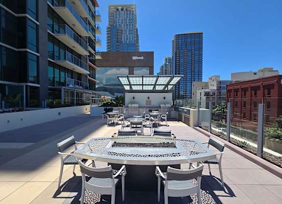 A table with chairs is set up on a rooftop patio.