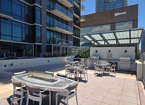 A patio with a table and chairs is surrounded by buildings.