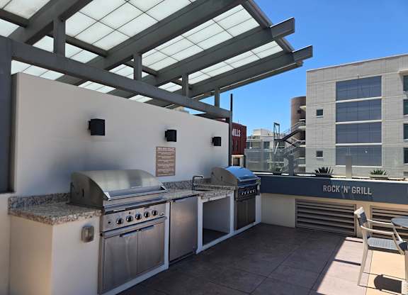A patio with a grill and a table.
